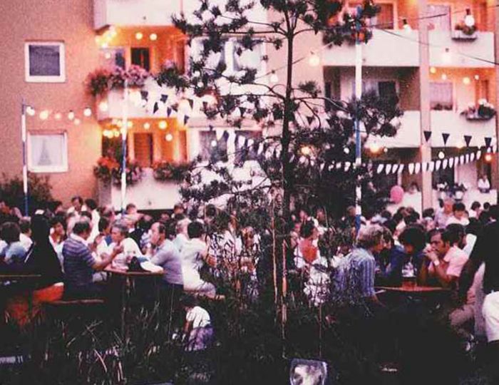 Viele Menschen im Innehof eines Wohnblocks zum "Kennenlern Fest"